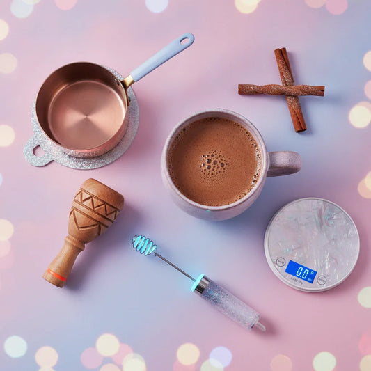 Ceremonial cacao tools flat lay with mug, whisk, and frother